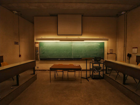 sala de aulas vazia com lousa verde ao fundo
