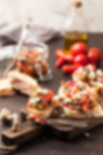 Picture of open-faced sandwiches with tomatoes and oil in the background.