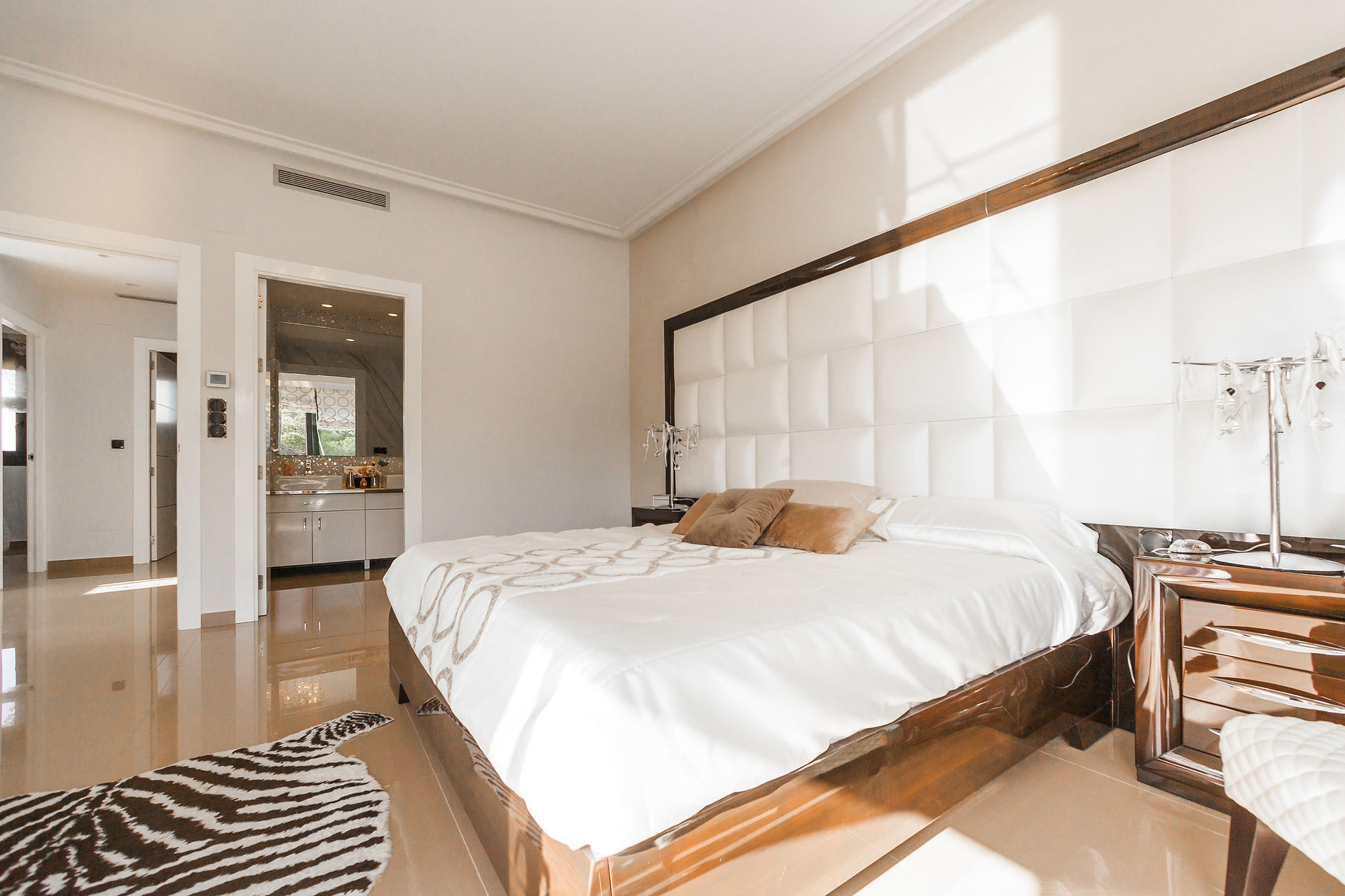 Une chambre pour enfant élégante avec un tapis zèbre et un lit blanc, créant une atmosphère moderne et accueillante, alliant confort et contemporain.