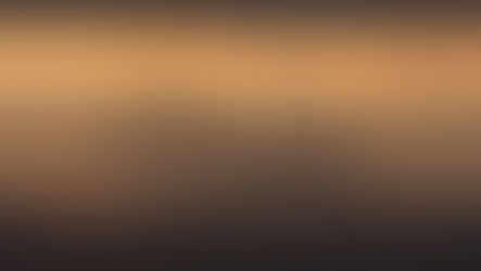 The sun shines through dark clouds onto a brown and orange desert landscape.
