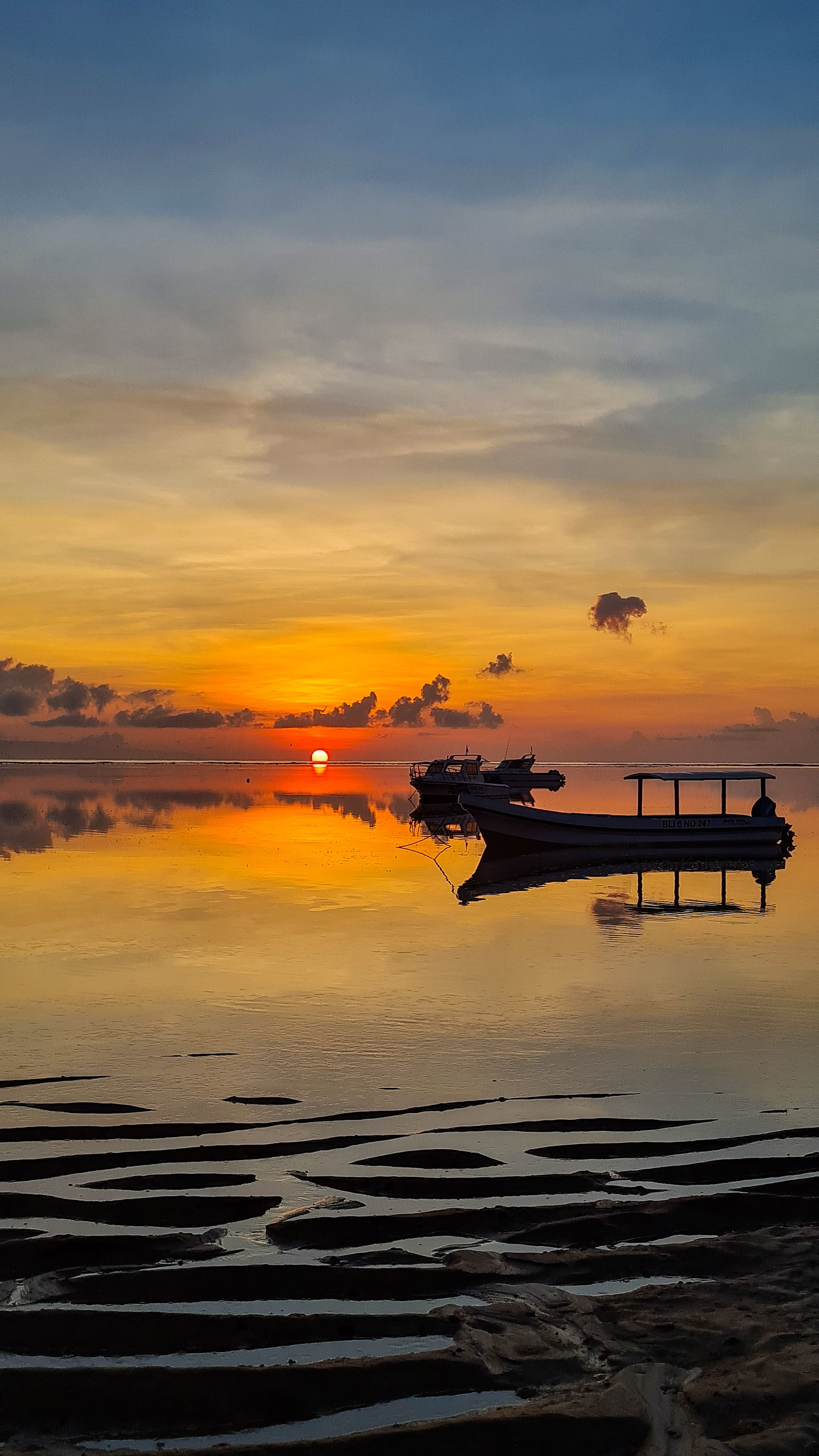 Sunset in Bali over water with a boat