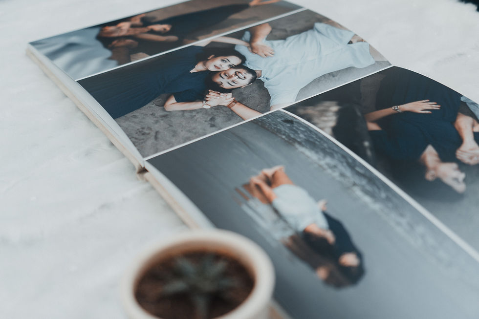 Open photo album showing a smiling couple in casual clothes on a grey floor, with soft, warm tones.