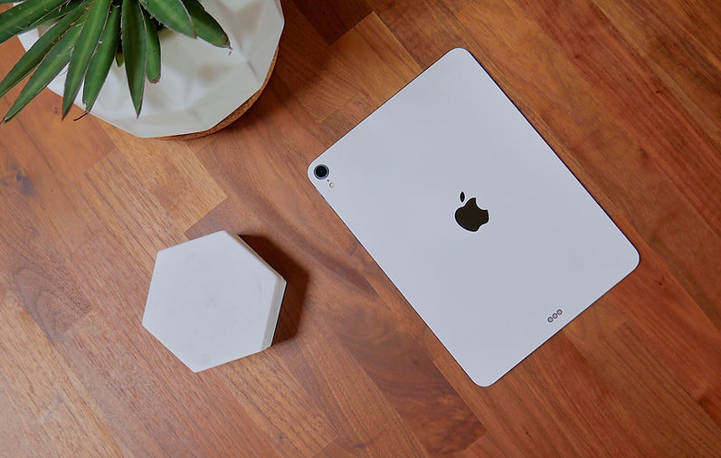 a repaired ipad laying face down on a wooden desk