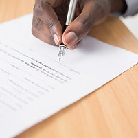 Person signing document with pen