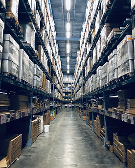 tall warehouse racks filled with product and bright lights overhead