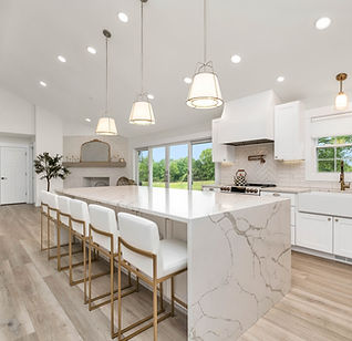 Bright, spotless white kitchen with a marble island