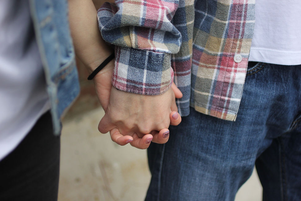 Two people holding hands, representing support and connection in relationships