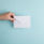 A hand holding a white unmarked envelope