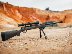 A hunting rifle resting on a ground