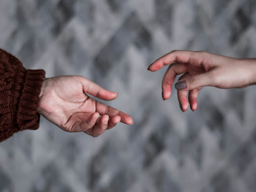 In a moment of personal psychic exchange, two hands reach towards each other, symbolizing a deep and intuitive connection beyond words.