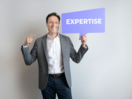 Man holding sign saying expertise