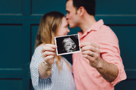 A couple holding a sonogram after acheiving natural fertility through acupuncture