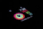 Smartwatch display in dark showing time 7:26, steps 985, heart rate 82 BPM, and activity rings in vibrant colors.