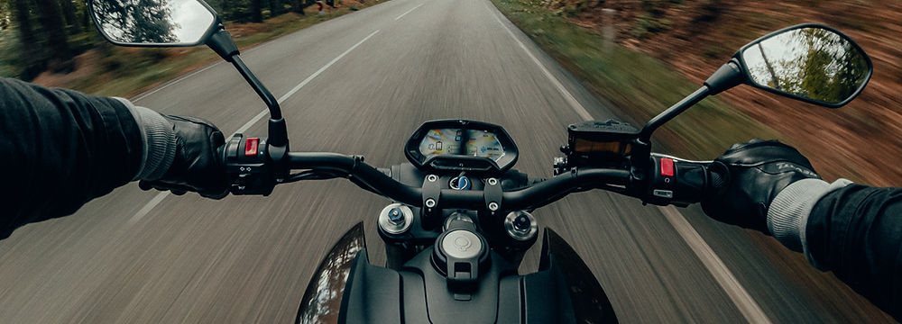 Motorrad auf der Landstraße. Training bei ProRide Motorrad ist individuell, emphatisch und genau auf Dich abgestimmt. Proride Motorrad Bike2Bike Coaching ist ein individuelles 1:1 Angebot für Motorradfahrerinnen und Motorradfahrer, die gezielt an Kontrolle, Sicherheit und Vertrauen arbeiten möchten. Im Fokus stehen nicht möglichst viele Übungen, sondern genau die Themen, die im Alltag wirklich relevant sind – zum Beispiel Langsamfahren, enge Kurven, Wendungen, Rangieren oder Unsicherheiten bei niedriger Geschwindigkeit. Die Trainings von Proride Motorrad sind ruhig, verständlich und mit einem klaren Blick für die Person auf dem Motorrad. Denn echte Sicherheit entsteht nicht durch Druck, sondern durch Verständnis, Kontrolle und Schritt für Schritt wachsendes Vertrauen.