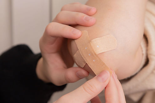 mains qui mettent un pansement sur un coude