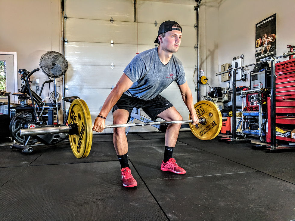 Man lifting weights in his gym, to manage anxiety and depression symptoms. Physical exercise can be one way for busy men in St. Louis to manage their mental health. Marble Wellness provides men's therapy in 63011 and surrounding zip codes. Call us today!