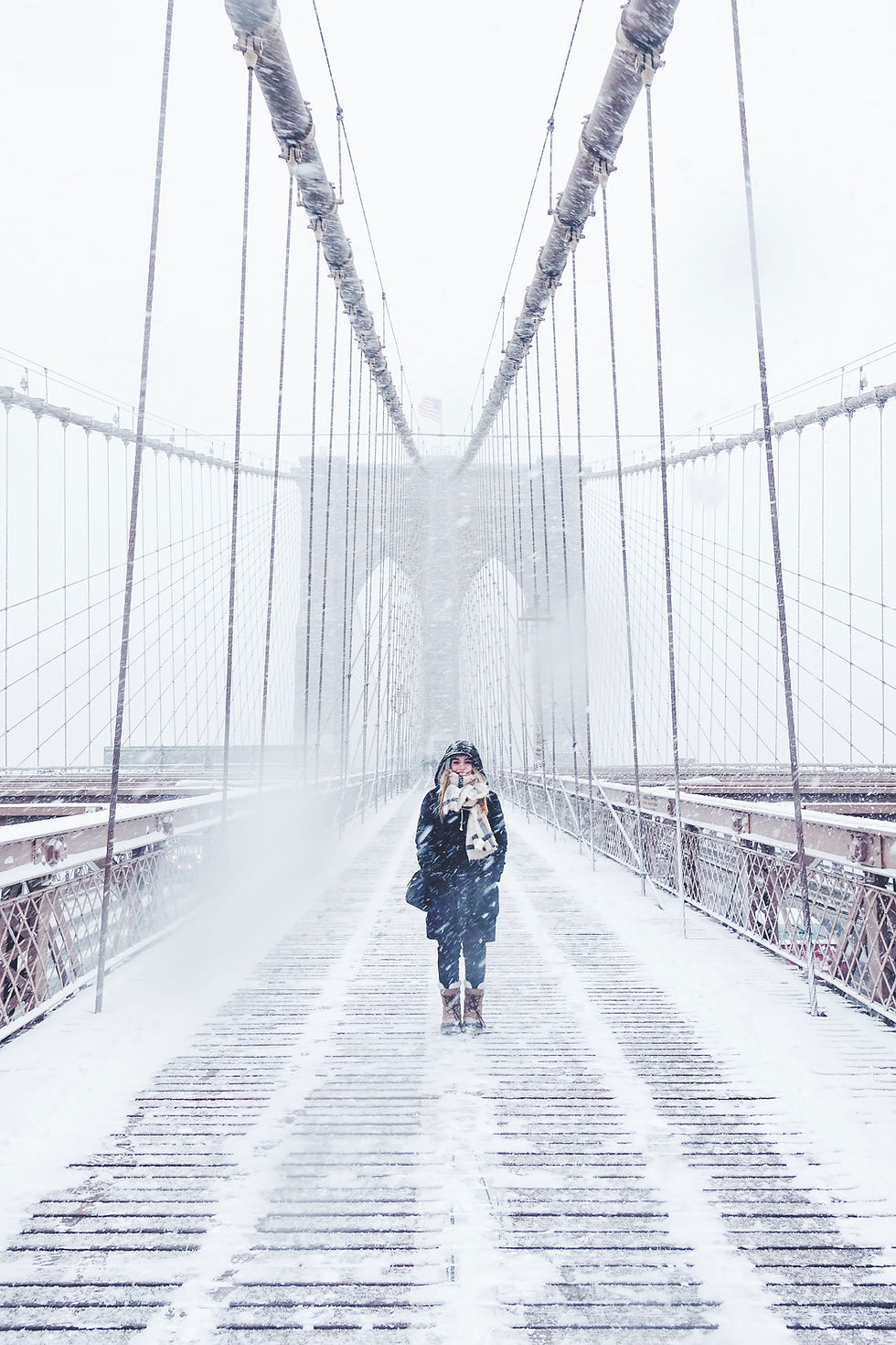 Woman walking on bridge covered in snow