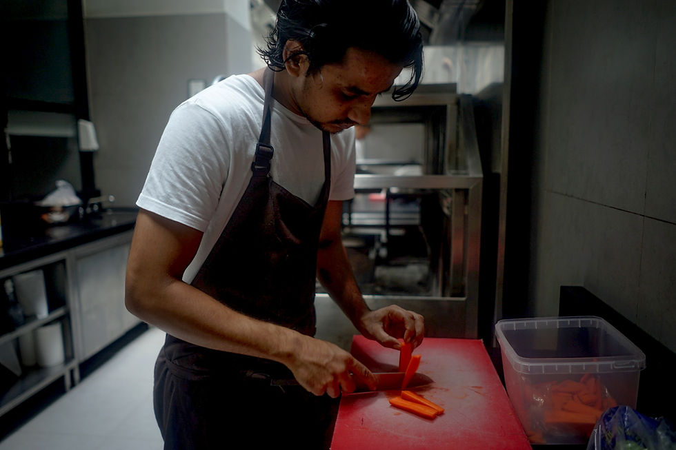 A man cuts food in a kitchen