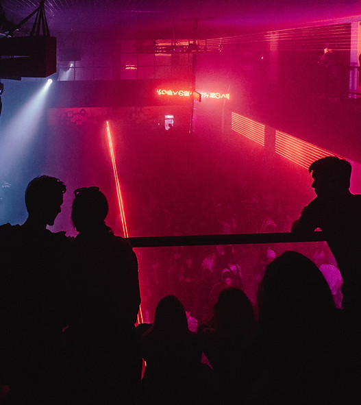 A crowd of people dancing in a club with people looking from above
