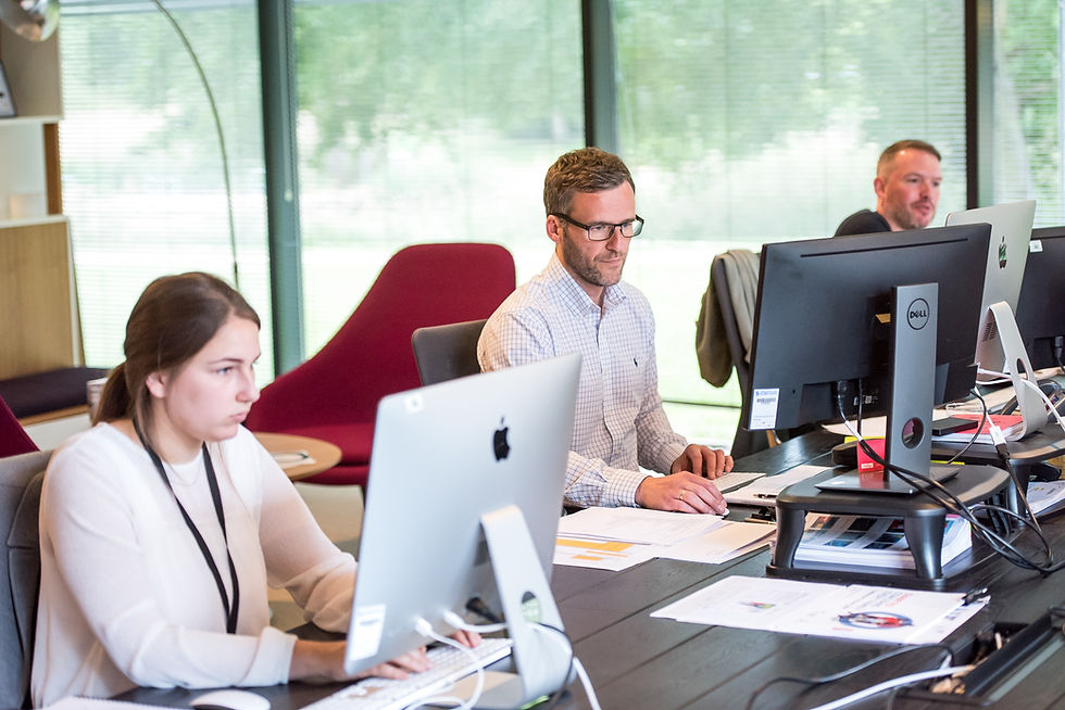 2 males and 1 female employees working at their desks on computer screens