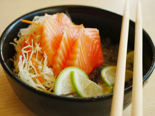 Drei Stücke Lachs mit Salat und Limette in schwarzer Schale – Omega-3-Fettsäuren, entzündungshemmend, Nervensystem stärken