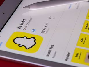 iPad showing Snapchat App Store page with Apple Pencil, yellow app tiles and 3.6-star rating on white screen