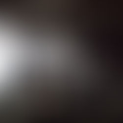 Film crew in a dimly lit studio, setting up equipment and monitors. Cables and spotlights surround them, creating a busy, focused atmosphere.