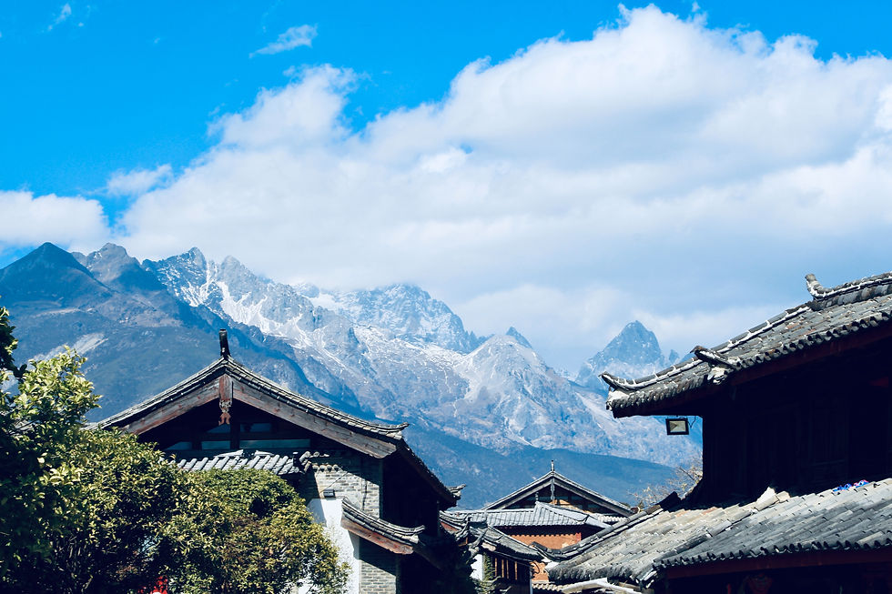 Vue sur les toits de Lijiang avec les montagnes enneigées du Yulong en arrière-plan, un panorama emblématique du Yunnan.