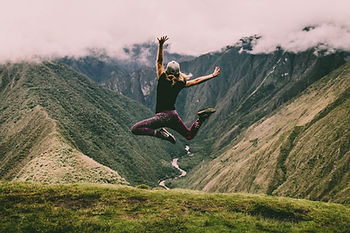 Femme qui saute devant des montagnes