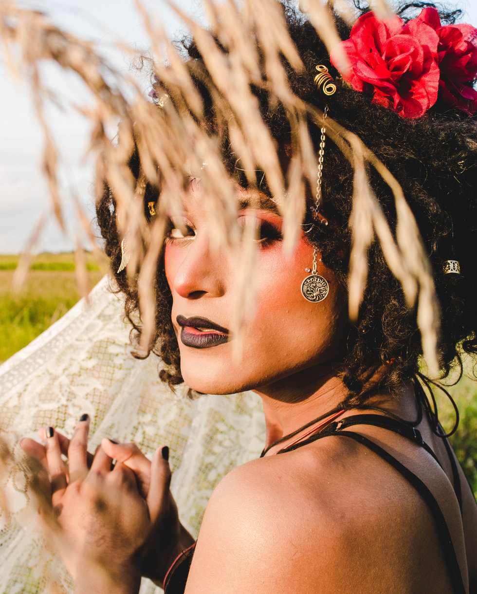Woman with curly hair framed by dried grasses