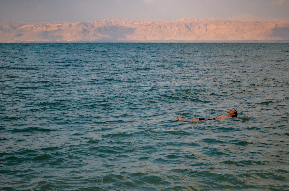 A man floating on his back in a large lake.