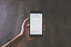 Hand holding phone reading mobile use article