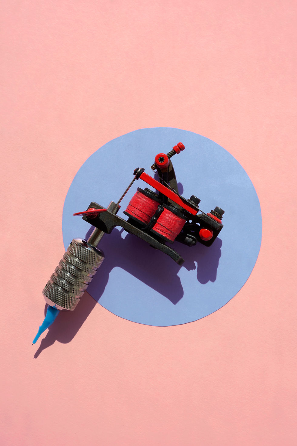 a tattoo gun on a peach background