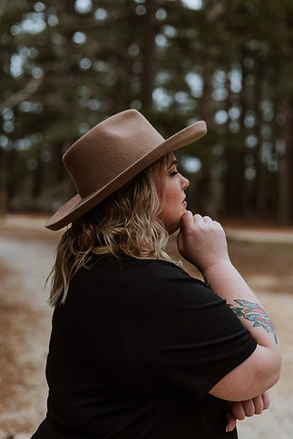 Woman with hat on and hand on chin staring off into the distance, contemplating life before CBT