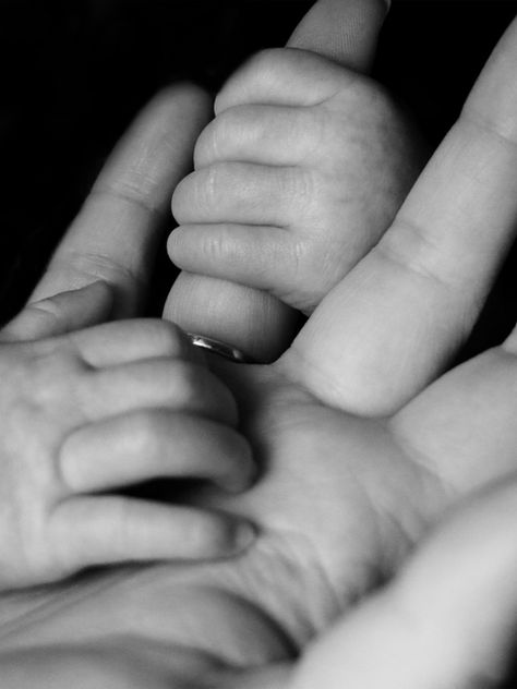 Close-up of a mother's hand holding a baby's.