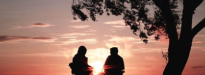 couple in sunset with fire under tree