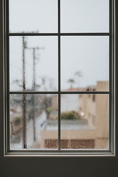 Raindrops on a window with frosted cityscape in the background