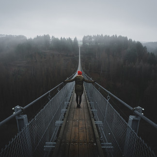 Frau geht ängstlich über die Brücke