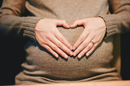 Ventre femme enceinte main en coeur