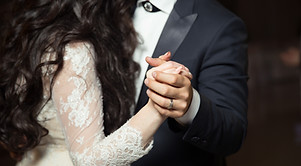 close-up image of hands of bride and groom while dancing