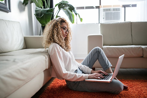 young woman working on her laptop on her living room floor