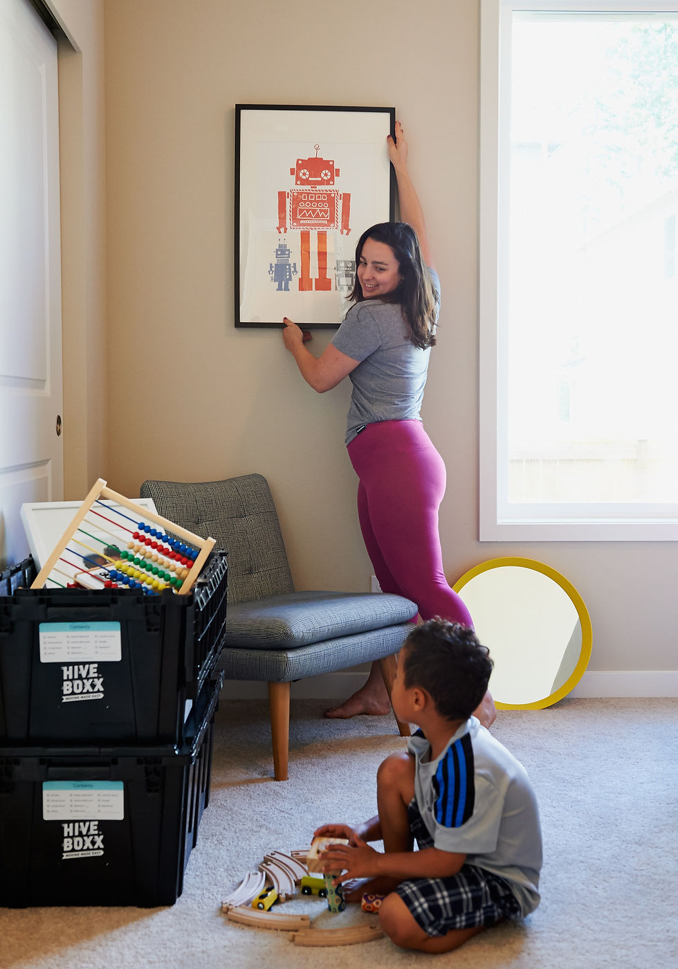 Woman hanging picture for her son