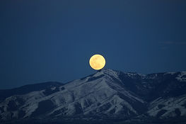 Full moon above mountains representing natural flow and Taoist balance