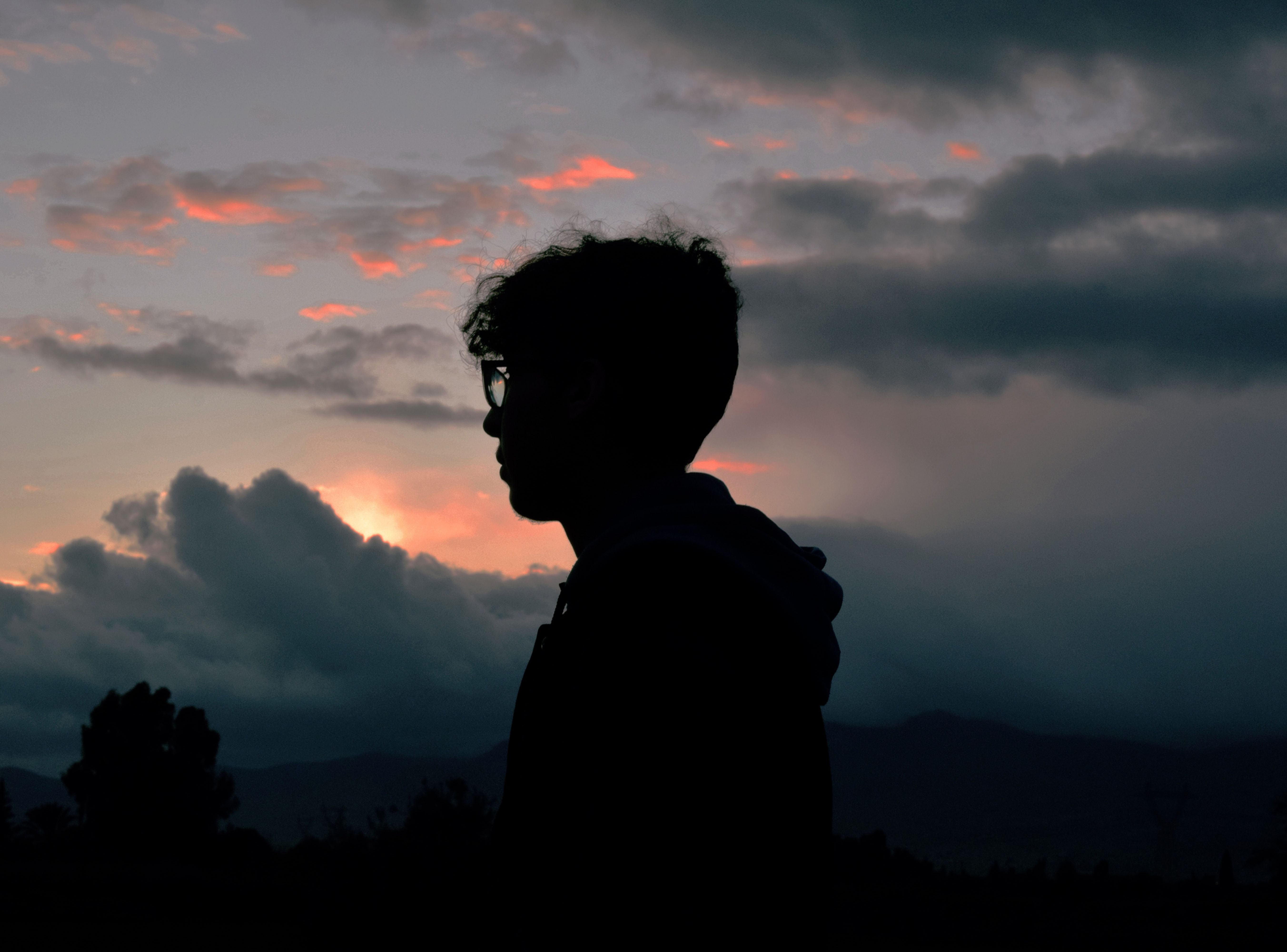 Profile picture of person against a dark sky and mountains