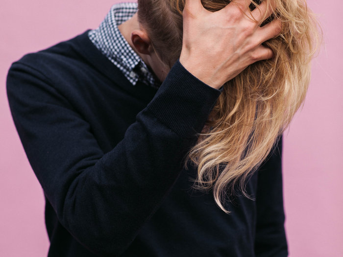 Two people embracing, one hiding their face in the other's hair