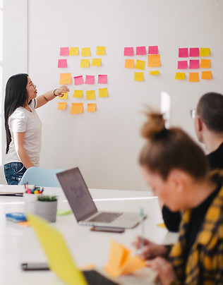 A boardroom meeting with sticky notes on the whiteboard.
