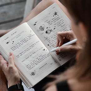 Woman writing in a journal as part of an emotional wellbeing routine