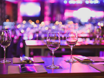 Wine glasses on a table with a blurred bar behind them 