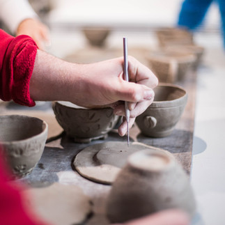 A person decorating a ceramic plate