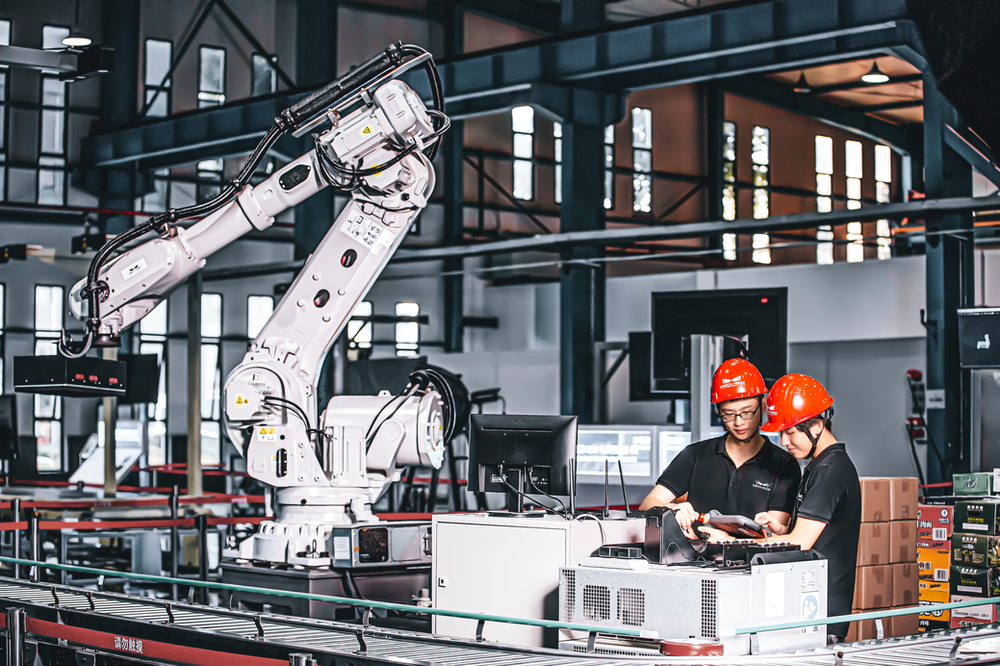 Two workers looking at a tablet in a manufacturing plant